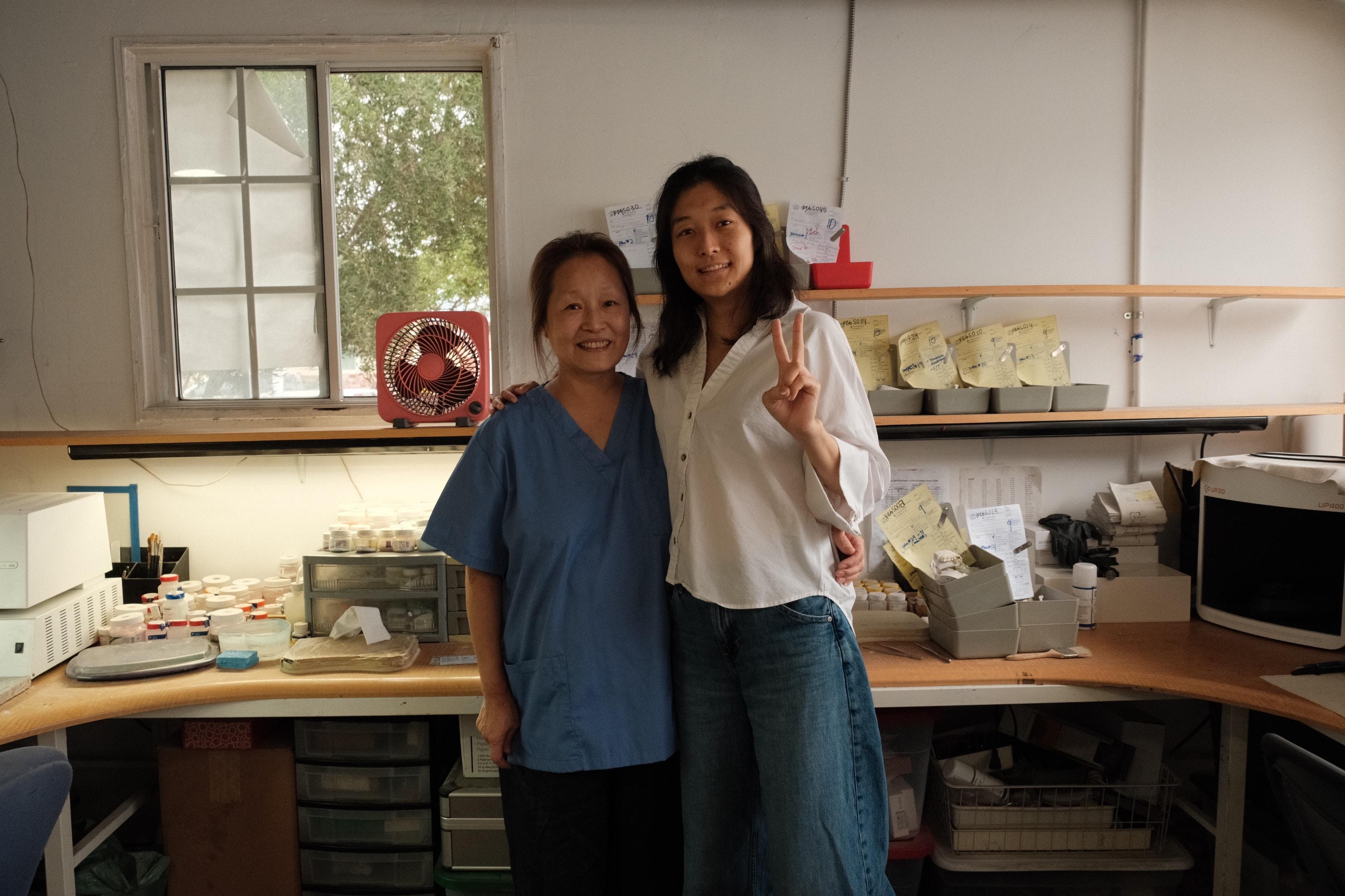The mother and daughter who run Ivy Dental Lab, standing together at the bench