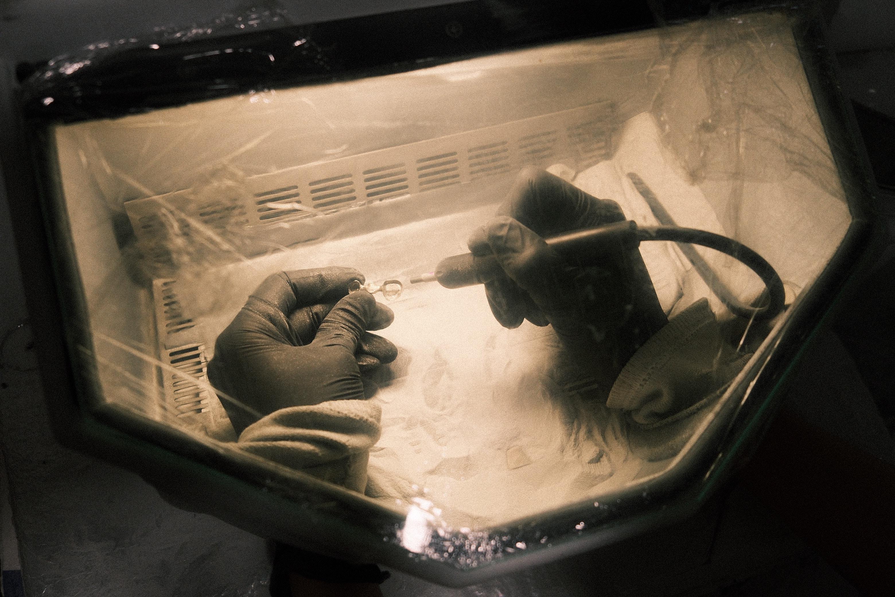 Sandblasting a multi-unit restoration inside the lab's blasting cabinet